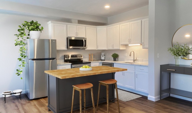 Spacious and well lit kitchen with wood floors and stainless steel appliances