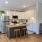 Spacious and well lit kitchen with wood flooring and stainless steel appliances