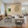 Spacious and well lit living room with wood flooring, large windows and open access to the kitchen